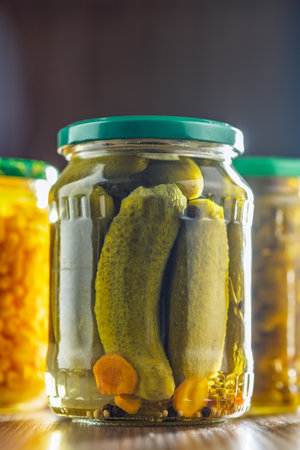 Pickles. Marinated cucumbers in a jar on a wooden table.の写真素材