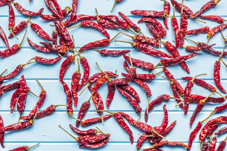 Dried red chili peppers on a blue table. Top view.
