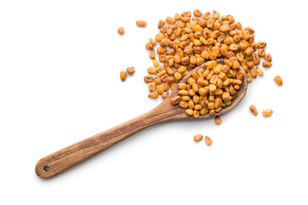 Roasted salted corn snack on wooden spoon isolated on a white background.の写真素材