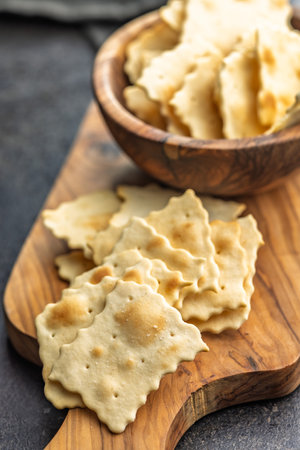 A crispy salted crackers on a cutting board on a black table.の写真素材