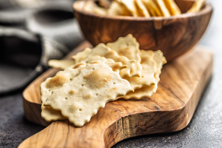 A crispy salted crackers on a cutting board on a black table.の写真素材