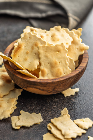 A crispy salted crackers in a bowl on a black table.の写真素材