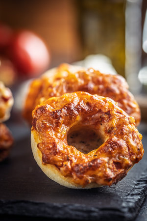 Mini pizza bagels on a cutting board on a black table.の写真素材