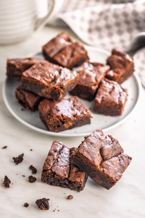 Homemade chocolate brownies on a plate on a kitchen table.の写真素材