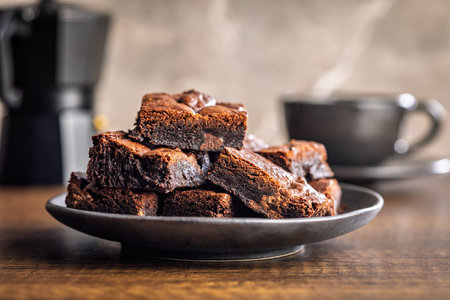 Homemade chocolate brownies on a plate on a wooden table.の写真素材