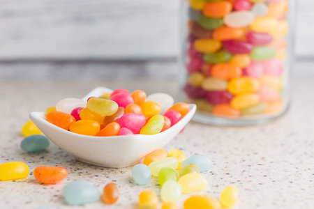 Multicolored jelly beans with various flavors in a bowl on a kitchen table.の写真素材