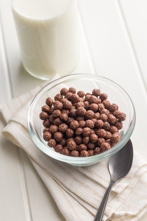 Breakfast cereal chocolate balls in a bowl on a white table.の写真素材