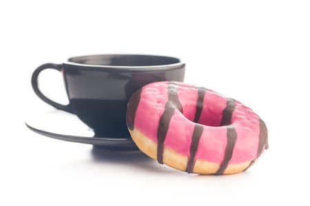 Sweet pink donut with chocolate strips and coffee cup isolated on a white background.の写真素材