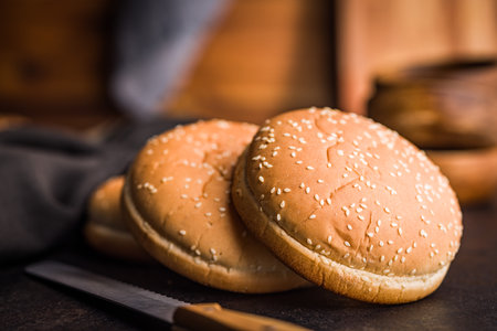Burger bun with sesame seeds on a black table.の写真素材