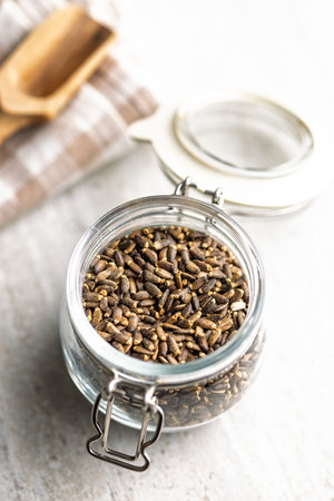 Milk thistle seeds in jar on a kitchen table.の写真素材