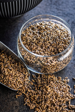 Milk thistle seeds in jar on a black table.の写真素材