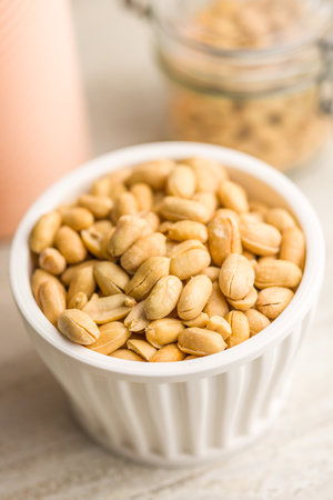 Roasted salted peanuts in a bowl on a kitchen tableの写真素材