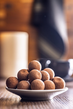 Chocolate truffles with cocoa powder on a wooden table.の写真素材