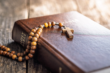 Wooden rosary beads and Holy Bible on a wooden table.の写真素材
