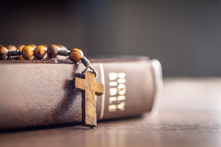 Wooden rosary beads and Holy Bible on a wooden table.の写真素材