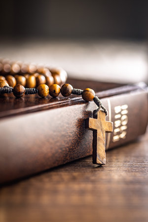 Wooden rosary beads and Holy Bible on a wooden table.の写真素材