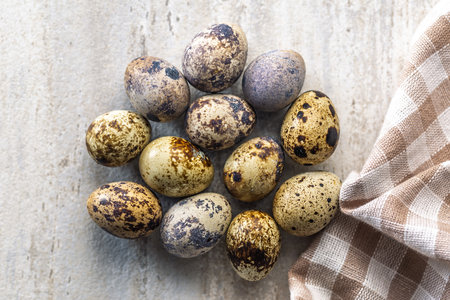 Spotted quail eggs on a kitchen table. Top view.の写真素材