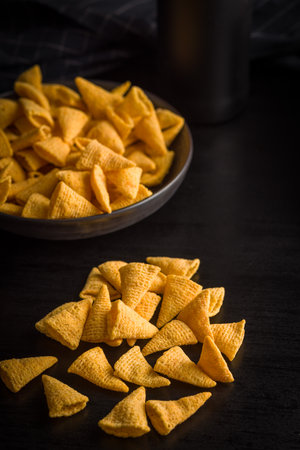 Salted snack chips on a black table.の写真素材