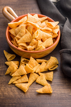Salted snack chips on a wooden table.の写真素材