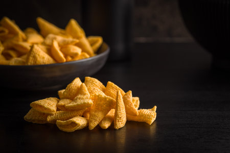 Salted snack chips on a black table.の写真素材
