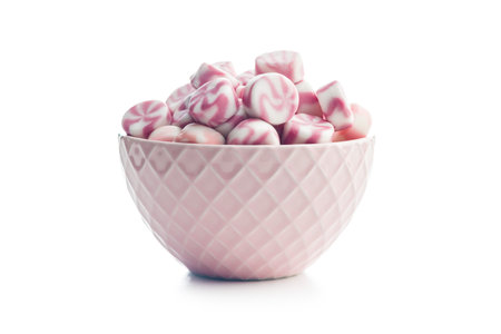 Colorful striped candies in bowl isolated on a white background.の写真素材