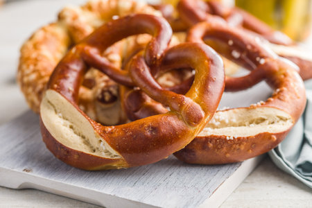 Salted bavarian pretzel on cutting board on a kitchen table.の写真素材