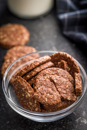 Sweet oatmeal cookies in a bowl on a black table.の写真素材