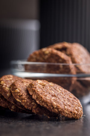Sweet oatmeal cookies on a black table.の写真素材