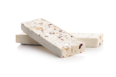 White nougat bars with almonds and dried fruit isolated on a white background.の写真素材