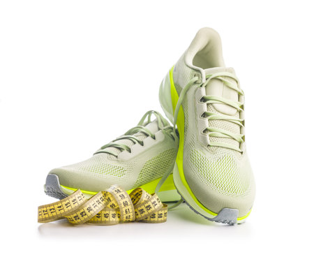 Sport running shoes and measuring tape isolated on white background.の写真素材
