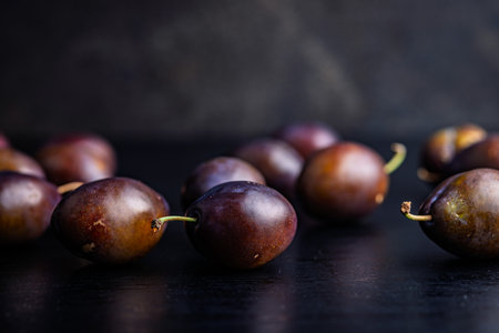 Ripe plums on a black table.