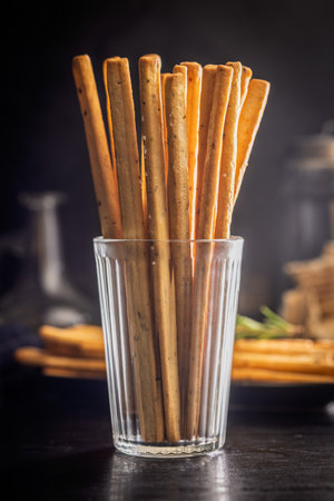 Crispy grissini breadsticks in cup on a black table.の写真素材
