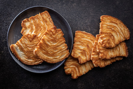 Le sfoglie. Crispy sweet pastry on a black table. Top view.