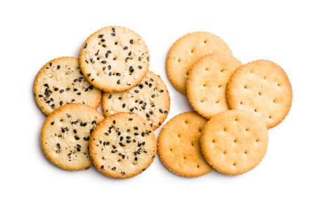 Crispy round salted crackers with sesame seeds isolated on a white background.の写真素材