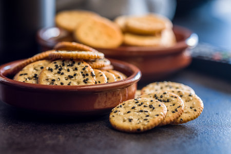 Crispy round salted crackers on a black table.の写真素材