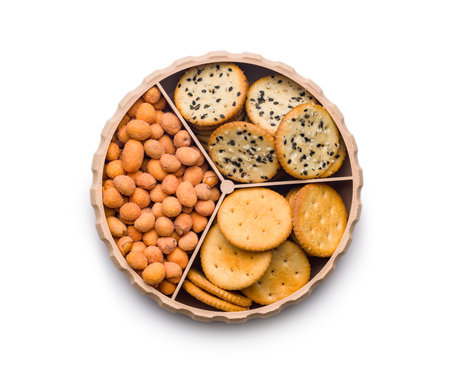 Various salty snacks in a round bowl isolated on a white background.の写真素材