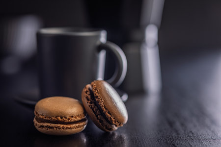 Different flavors of macarons. Colorful macarons on a black table.