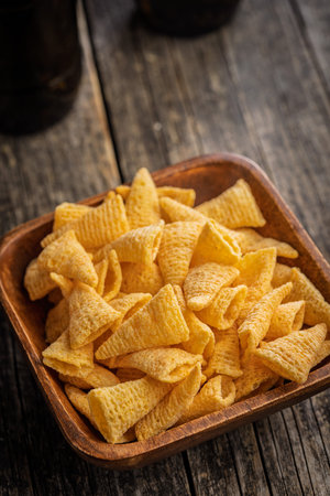 Cone corn chips in a bowl on a wooden table.