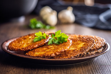 Fried potato pancake on a plate on a wooden table.の写真素材