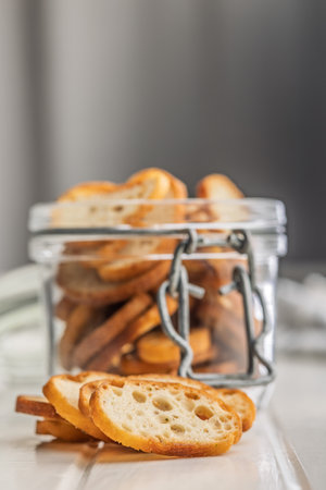 Crispy roasted bruschetta bread in a jar on a white table.の写真素材