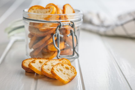 Crispy roasted bruschetta bread in a jar on a white table.の写真素材