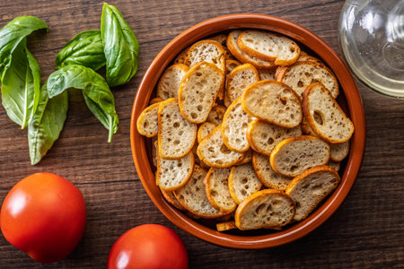 Crispy roasted bruschetta bread in a bowl on a wooden table. Top view.の写真素材