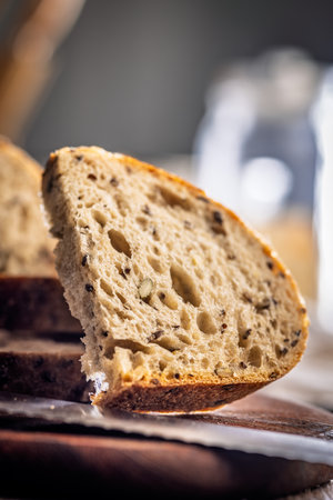 Photo of sliced â€‹â€‹â€‹â€‹baked sourdough bread on a cutting board on a wooden...