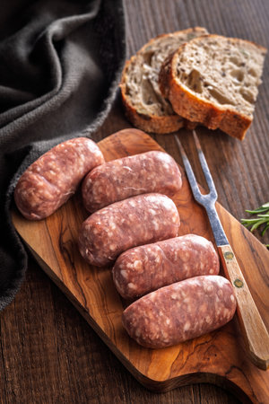Photo of Italian sausage salsiccia on a cutting board on a wooden table.の写真素材