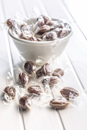 Sweet bonbon candies wrapped in foil on a white table.の写真素材