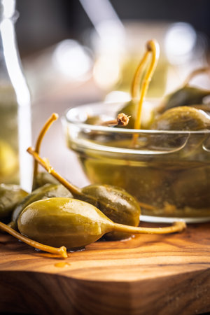 Pickled capers berries on a wooden cutting board.の写真素材