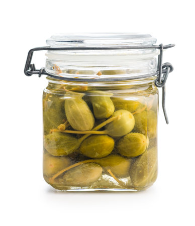 Pickled capers berries in jar isolated on a white background.の写真素材