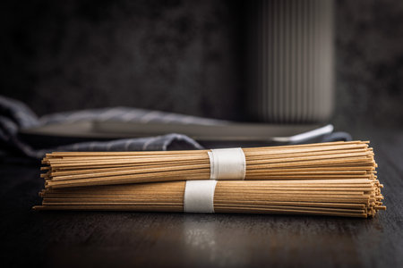 Buckwheat soba noodles on a black table.