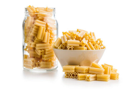 Uncooked italian pasta in a bowl isolated on a white background.の写真素材