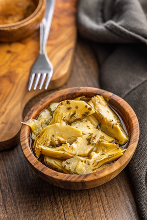 Pickled artichoke in bowl on a wooden table.の写真素材